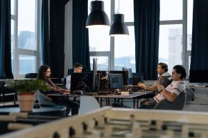 Workers collaborate in a modern office with computers, showcasing teamwork in technology development