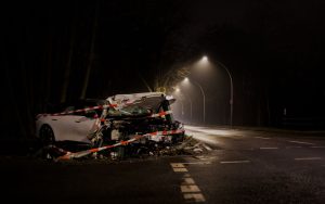 A wrecked car after a crash on a dimly lit street in Berlin at night