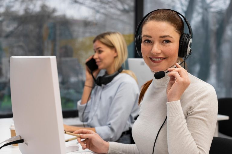 A customer service agent with a headset works at a computer