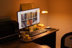 Warm-toned home office with computer setup, snacks, and ambient lighting