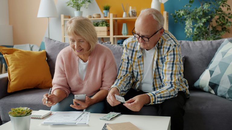 Older couple reviews retirement income documents at home