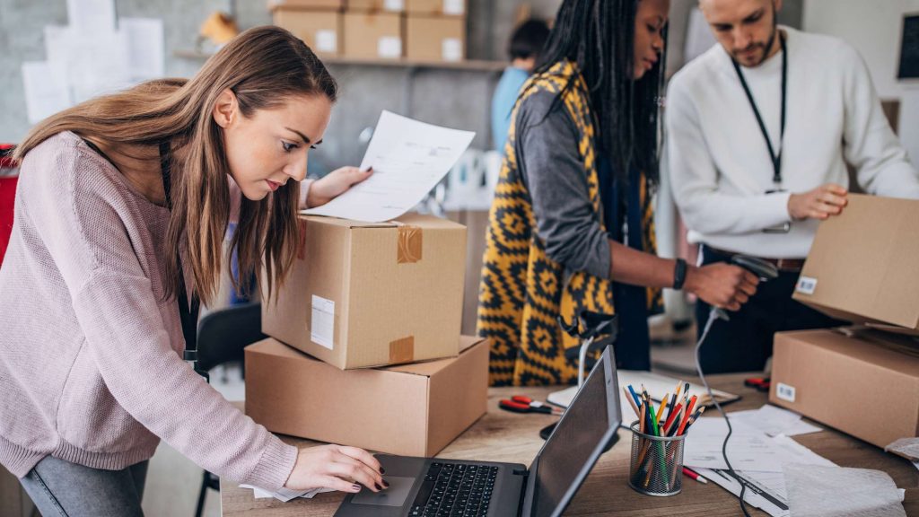 Workers packing customer orders among shipping boxes