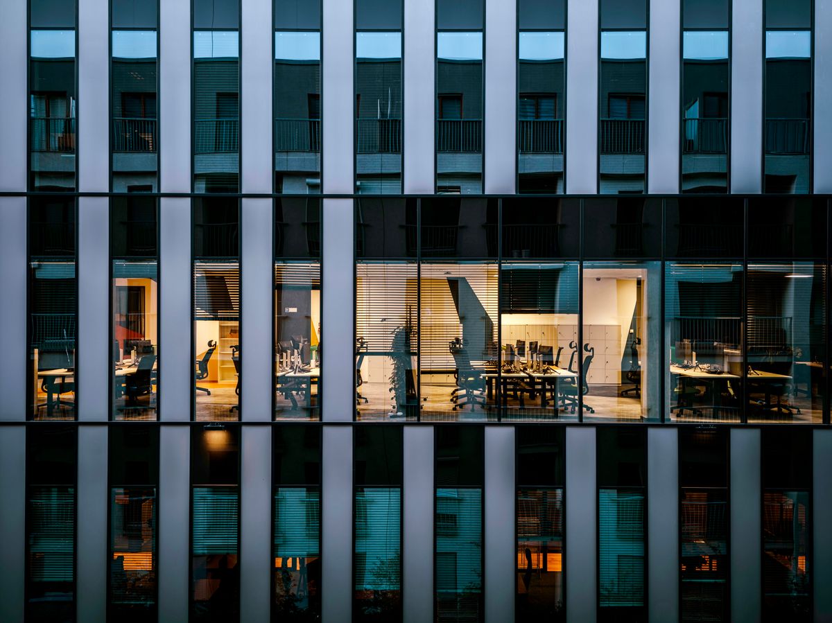 Illuminated offices seen through a glass building facade
